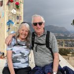 Volunteers Pat and Vince on holiday with a mountain landscape as a backdrop